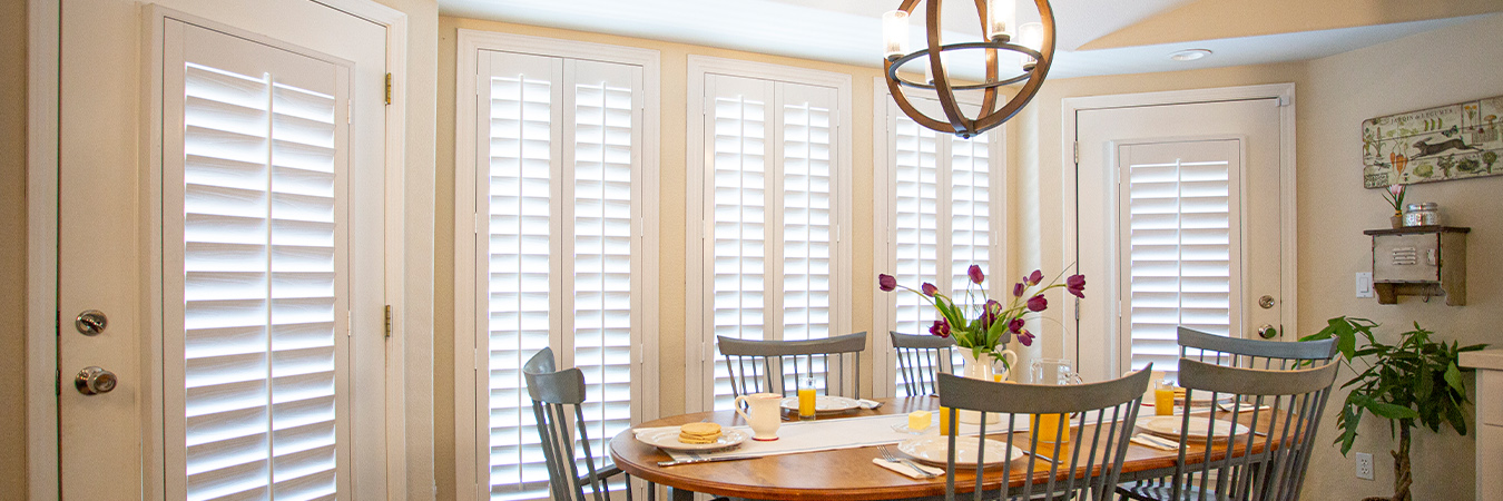 White Polywood shutters inside a dining room area.